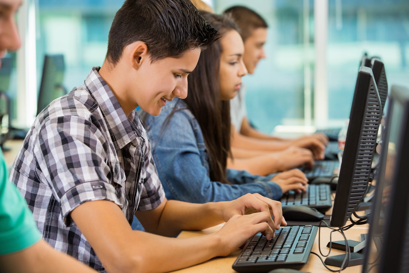 High school students typing during computer lab class